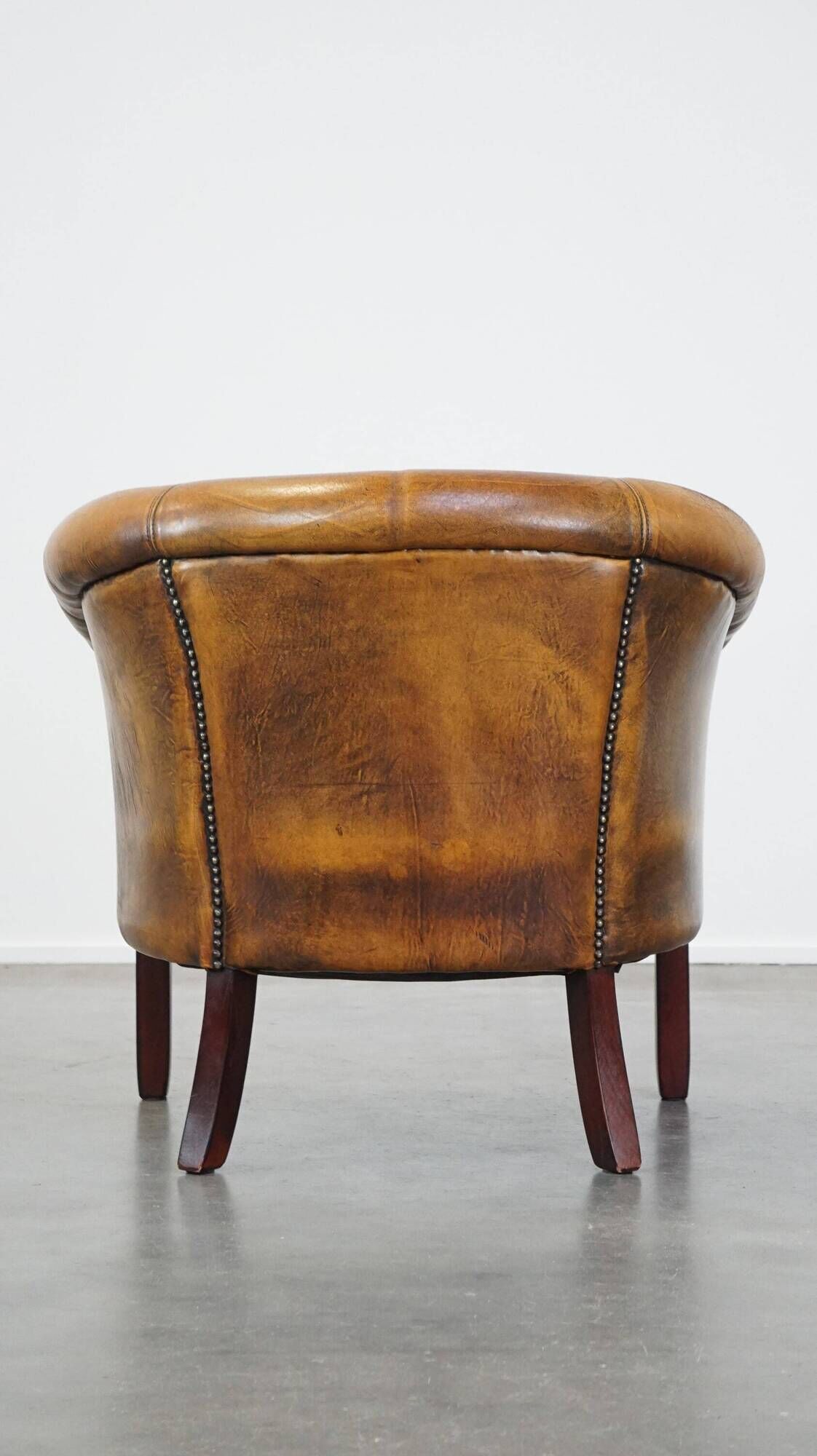 Fauteuil club en peau de mouton subtile avec finition cloutée décorative