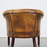 Subtle sheepskin club chair finished with decorative studs