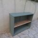 Vintage workshop furniture transformed into a re-enchanted bookshelf in smoky green.