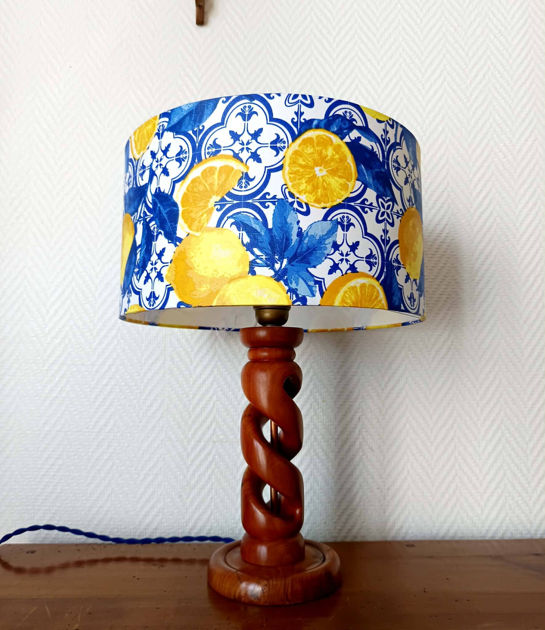 Turned wooden lamp with a lampshade featuring lemon tiles.