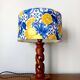 Turned wooden lamp with a lampshade featuring lemon tiles.