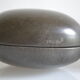 2 boxes in lithographed sheet metal in the shape of a pebble