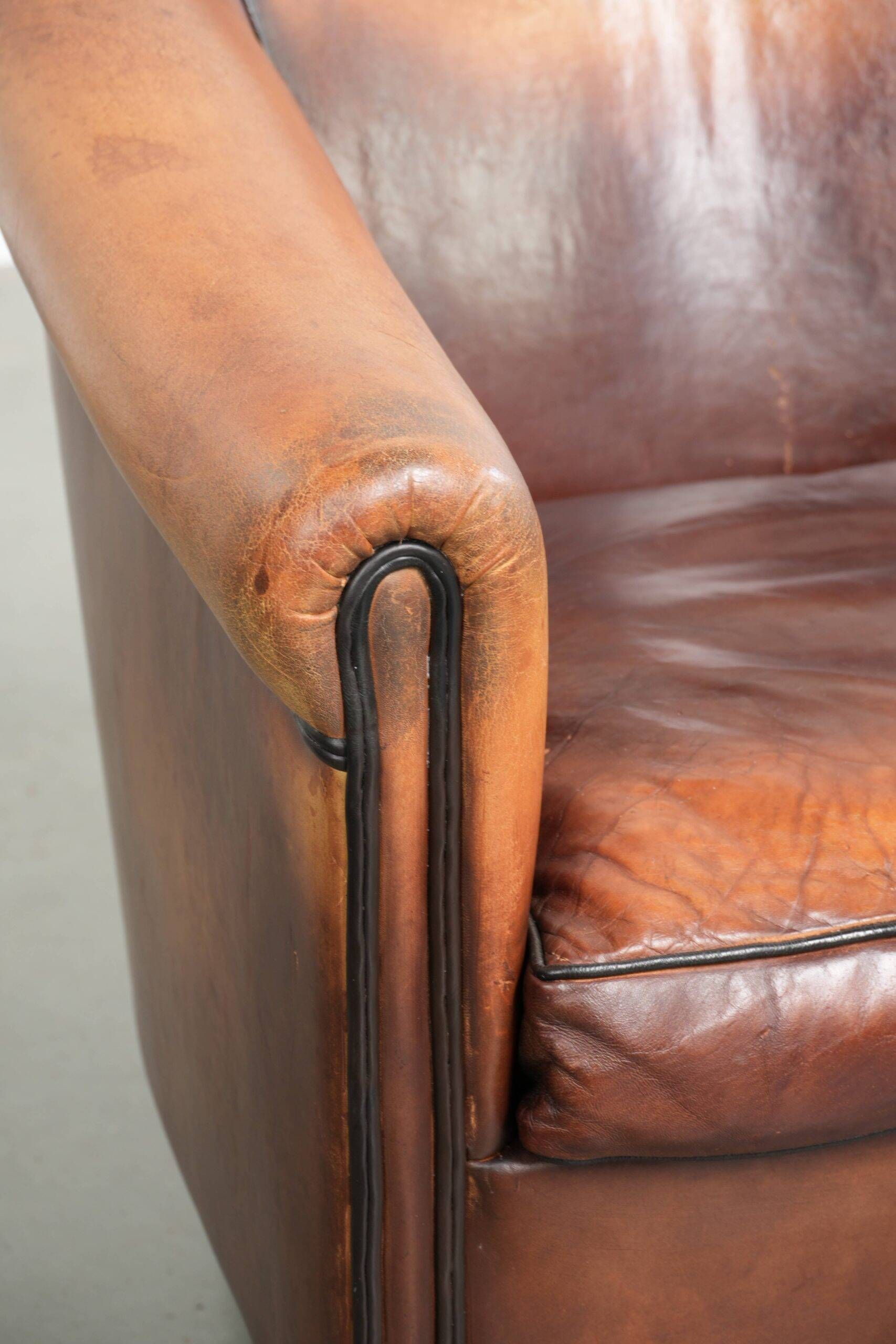 Vintage sheepskin club armchair finished with black piping