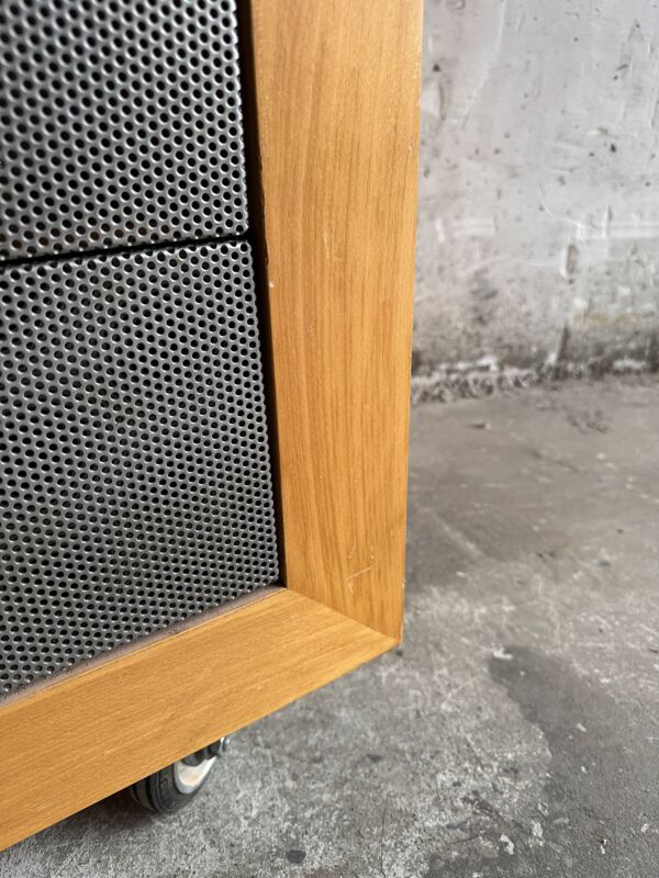 Meuble d'appoint en bois naturel avec façades en métal perforé gris foncé sur roulettes (bois massif et métal)