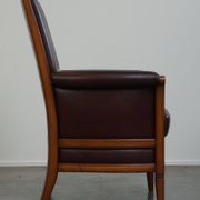 Very comfortable classic cowhide armchair with a high back in a mild Art Deco style