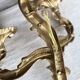 Vintage wall sconce in gold metal with two arms in classic style.
