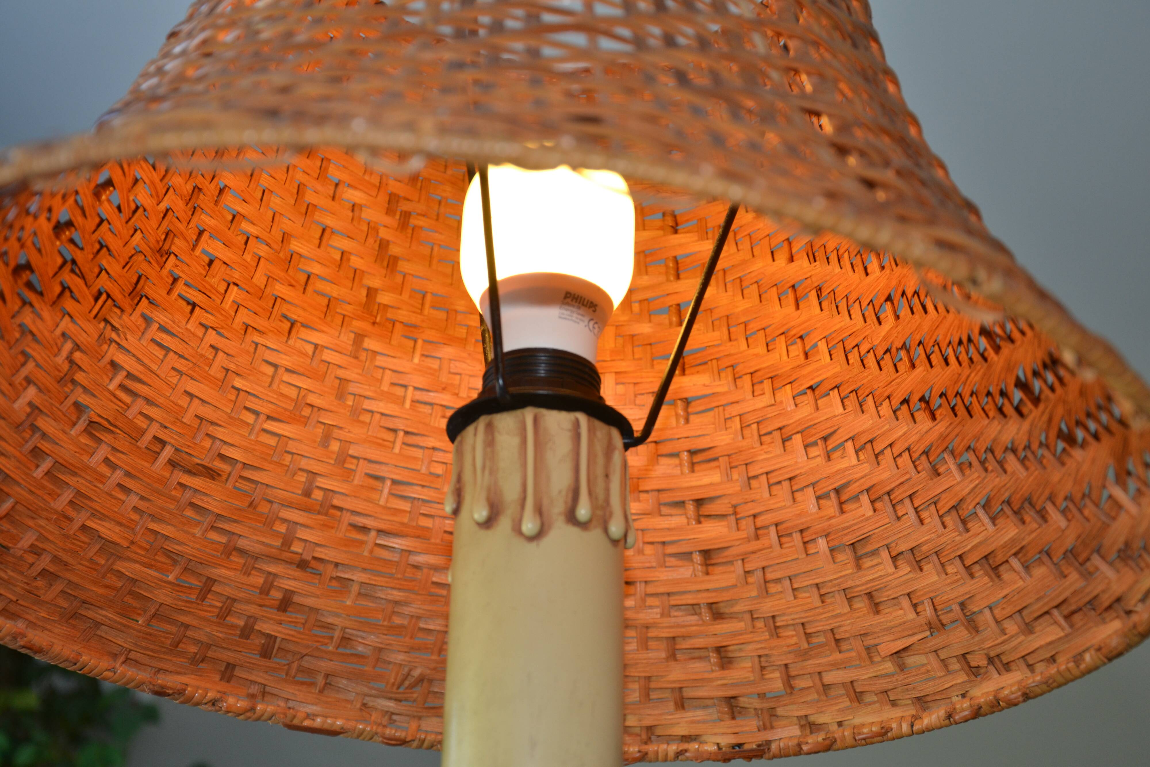 Large wooden lamp with a woven rattan shade.