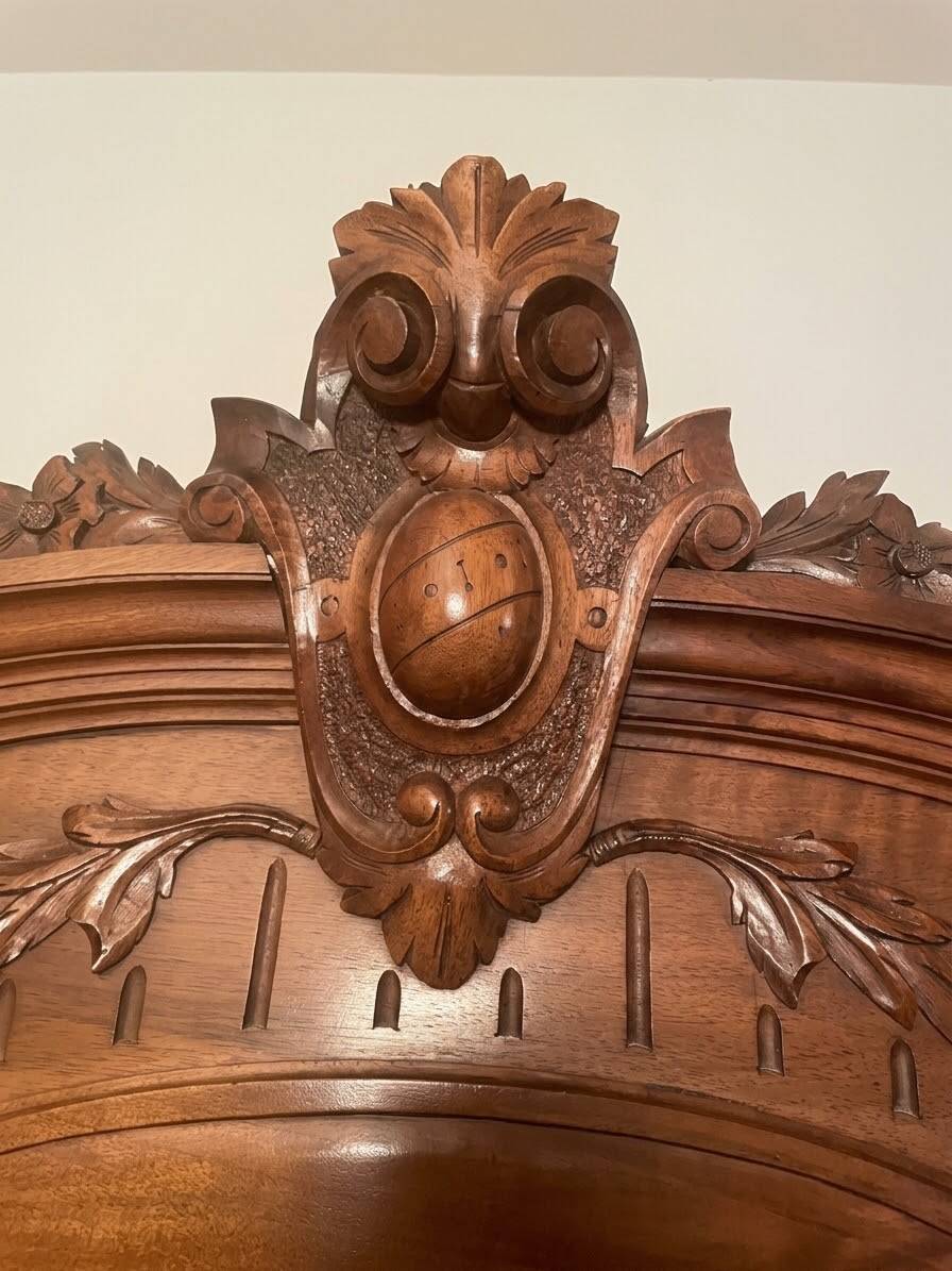 Antique solid wood wardrobe with an oval mirror.