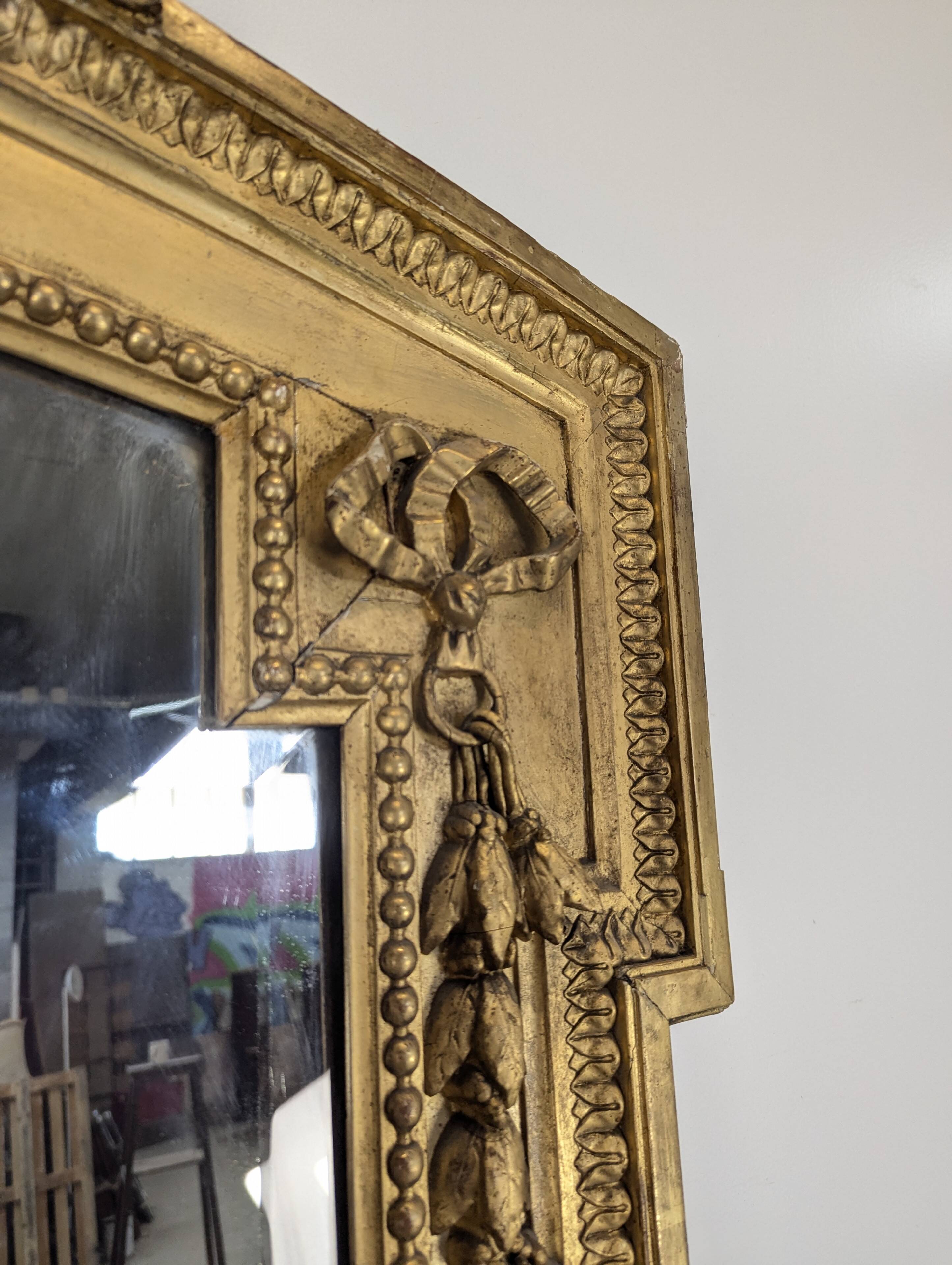 Large gilded wooden mirror in Louis XVI style from the late 19th century.