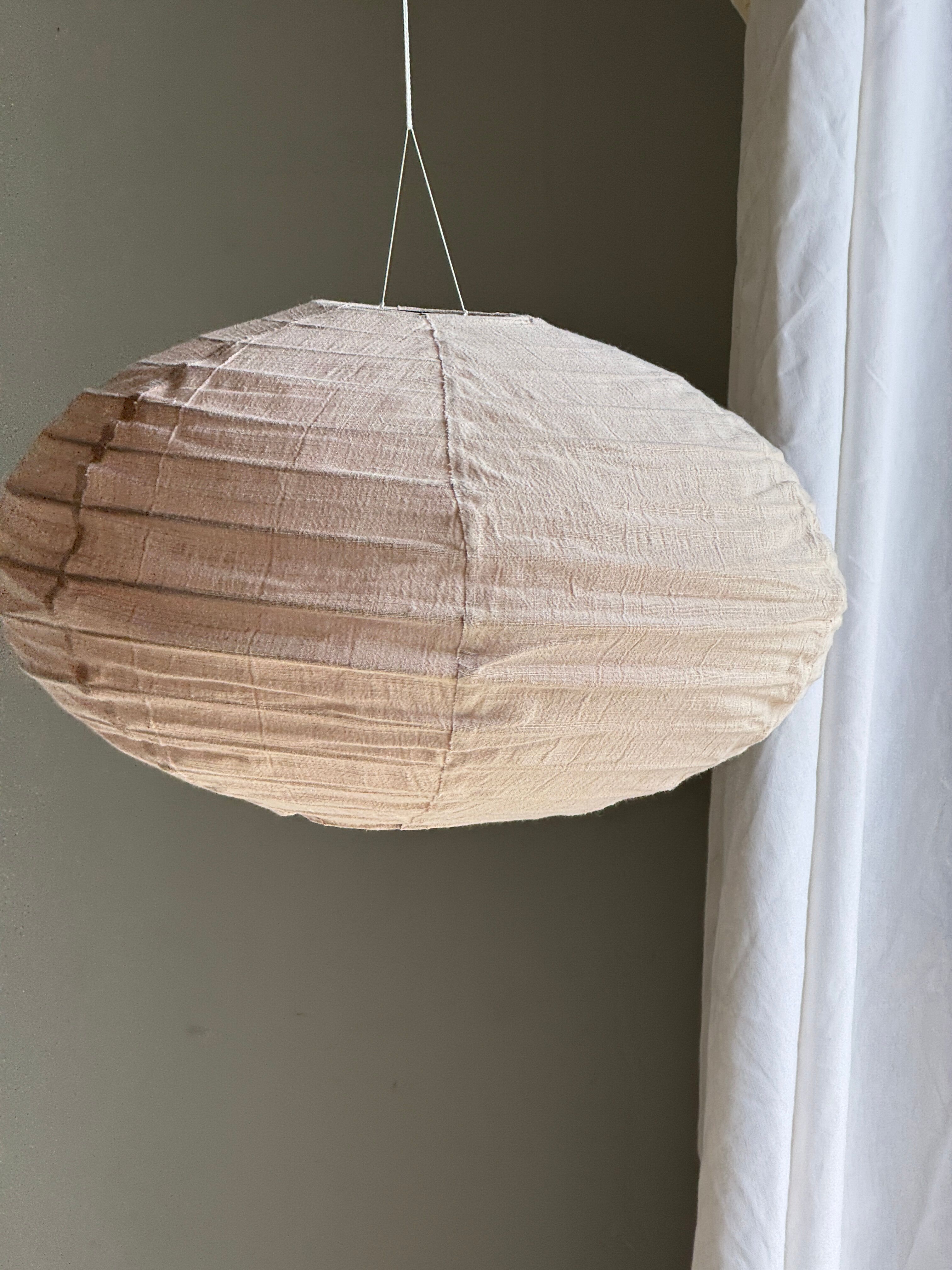 Average suspension in natural rattan and linen, Japanese-style, flattened oval in pink.