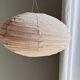 Average suspension in natural rattan and linen, Japanese-style, flattened oval in pink.