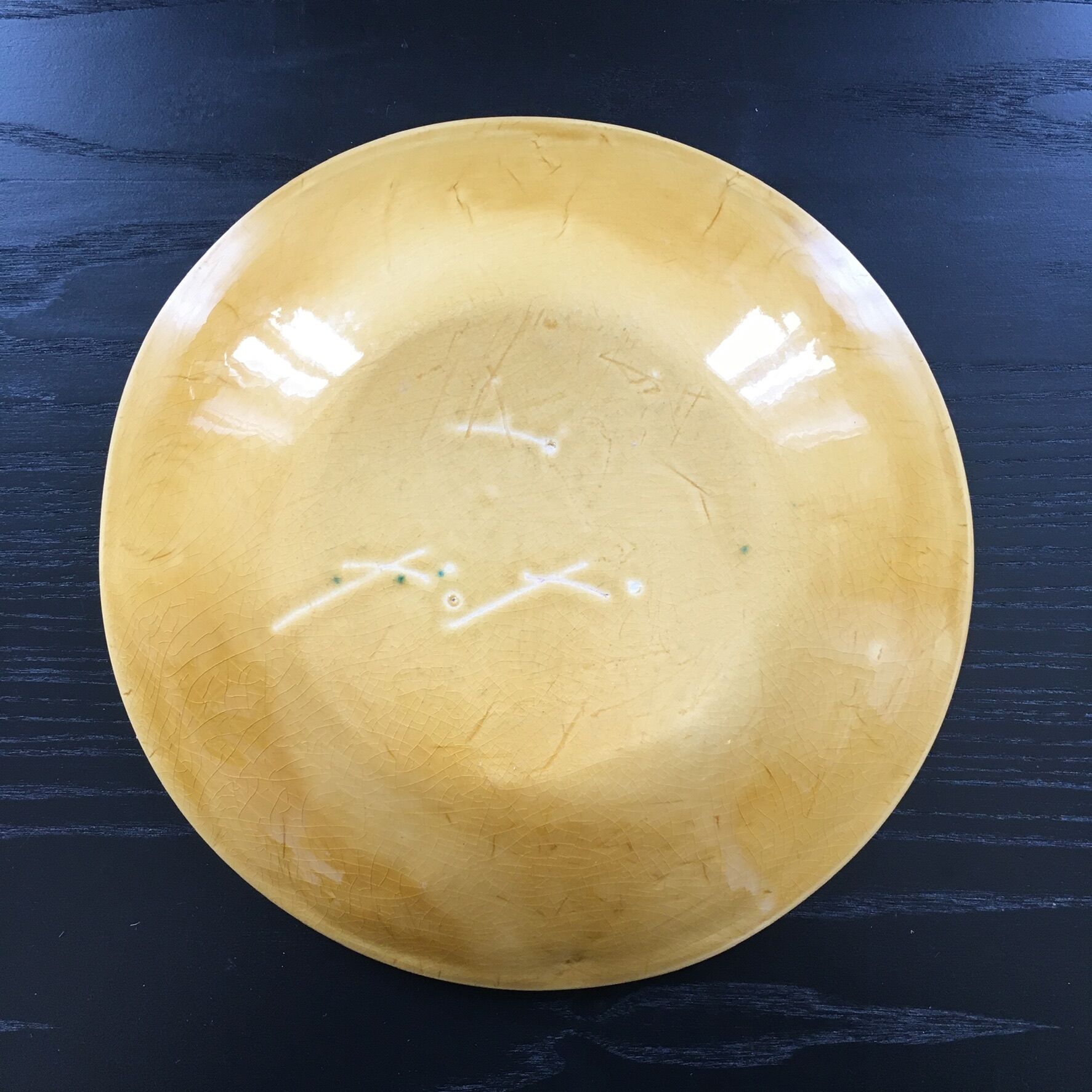 Plate signed with green leaf decoration.