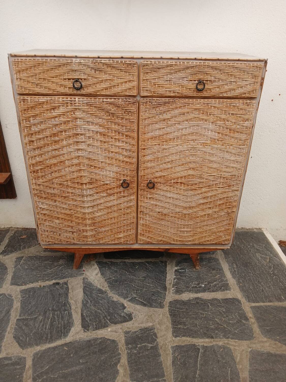Vintage woven rattan furniture with tapered legs.