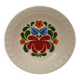 Hungarian folk plate in white ceramic with hand-painted flowers, embossed edge.