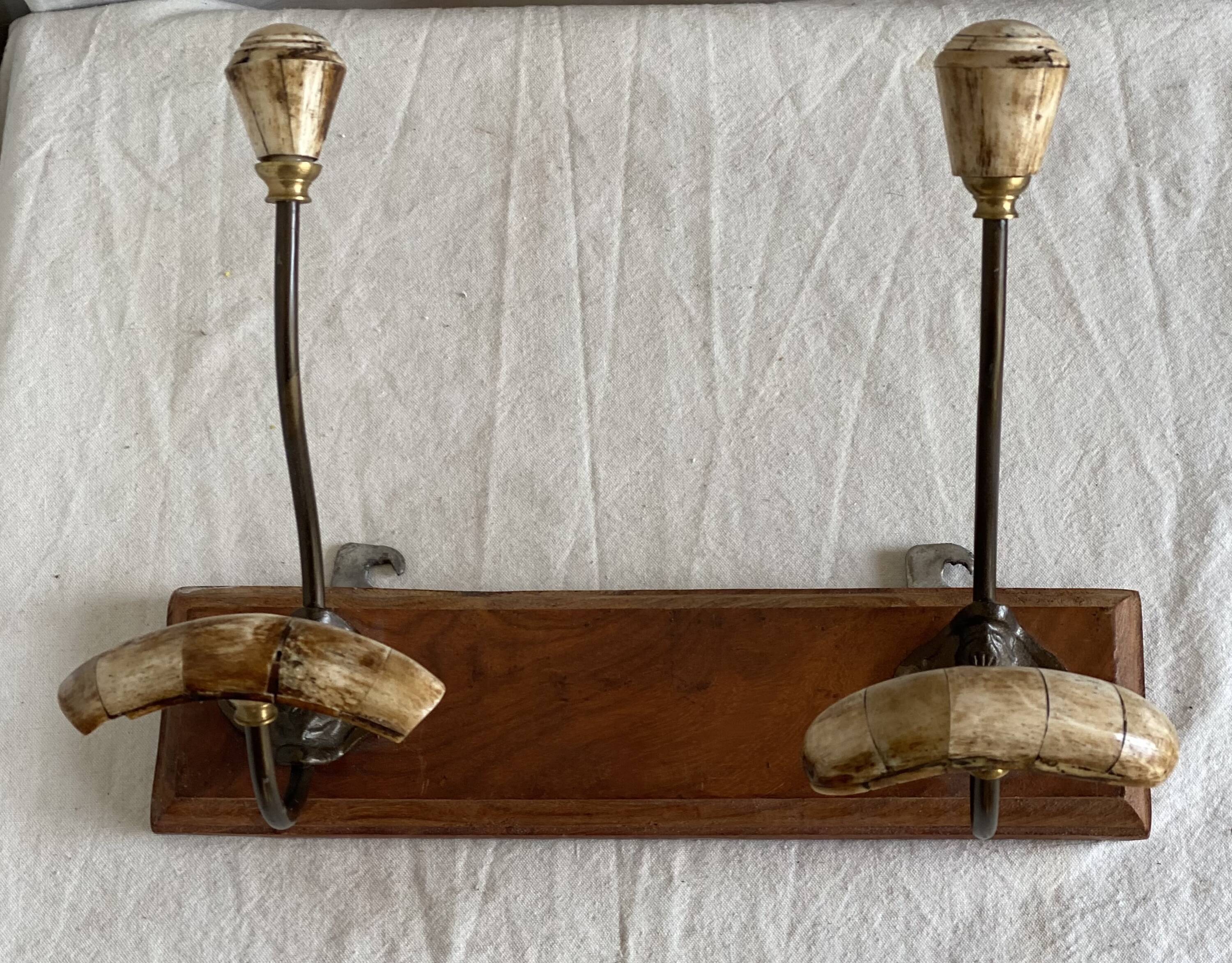 19th-century wall coat rack with 2 metal and horn hooks.
