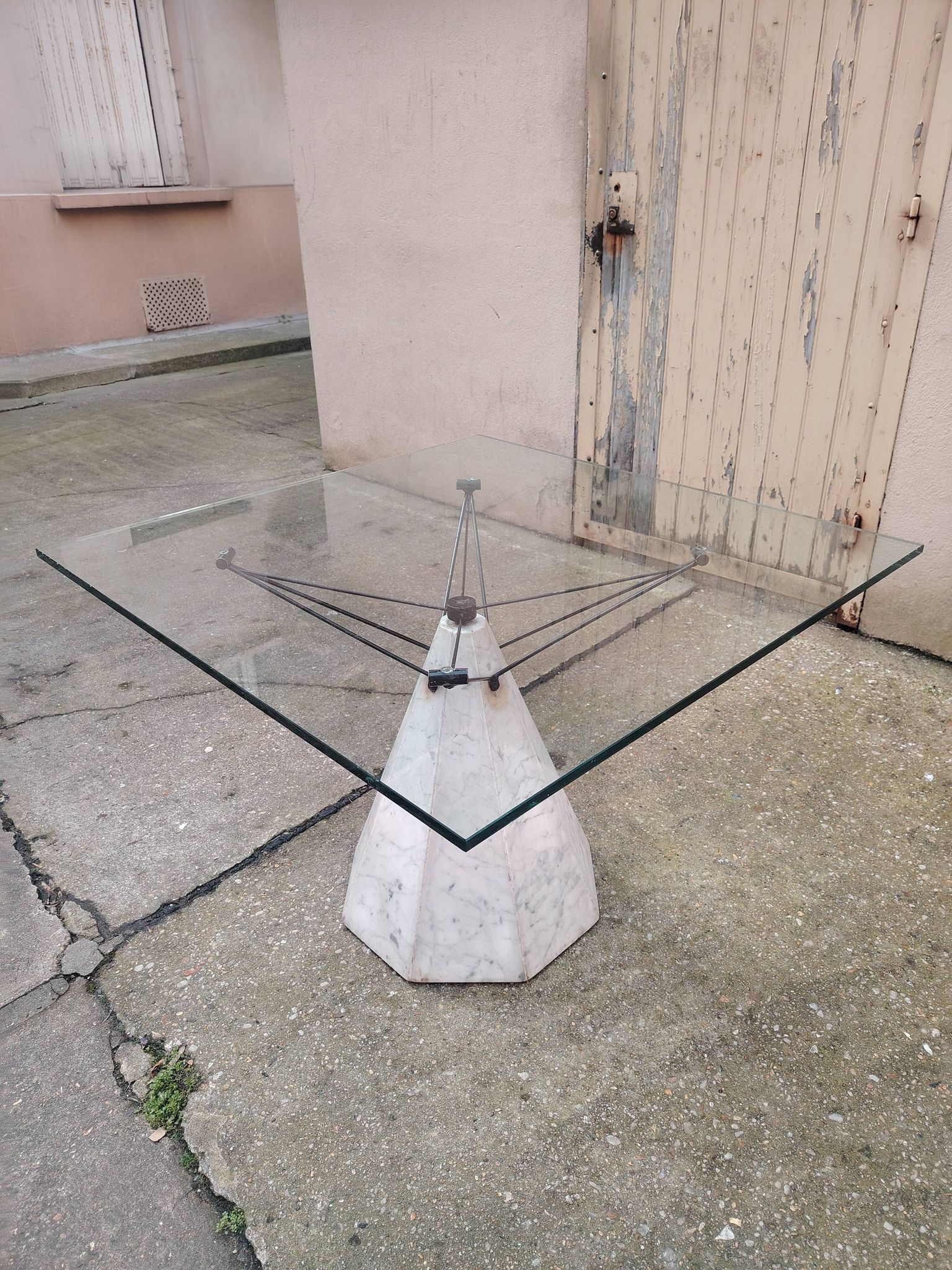 1980s table with a marble and steel base and a square glass top.