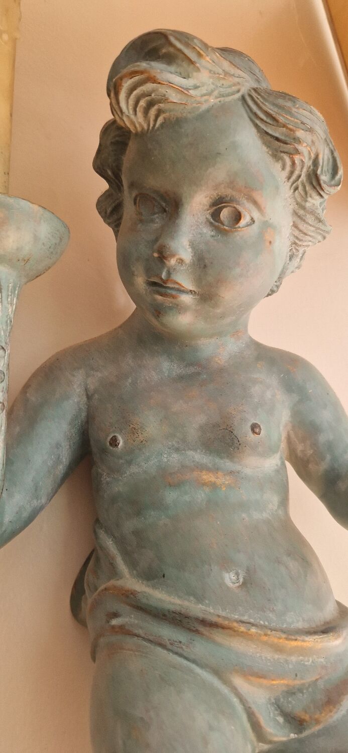 Pairs of wall lights, either two distinct cherubs.