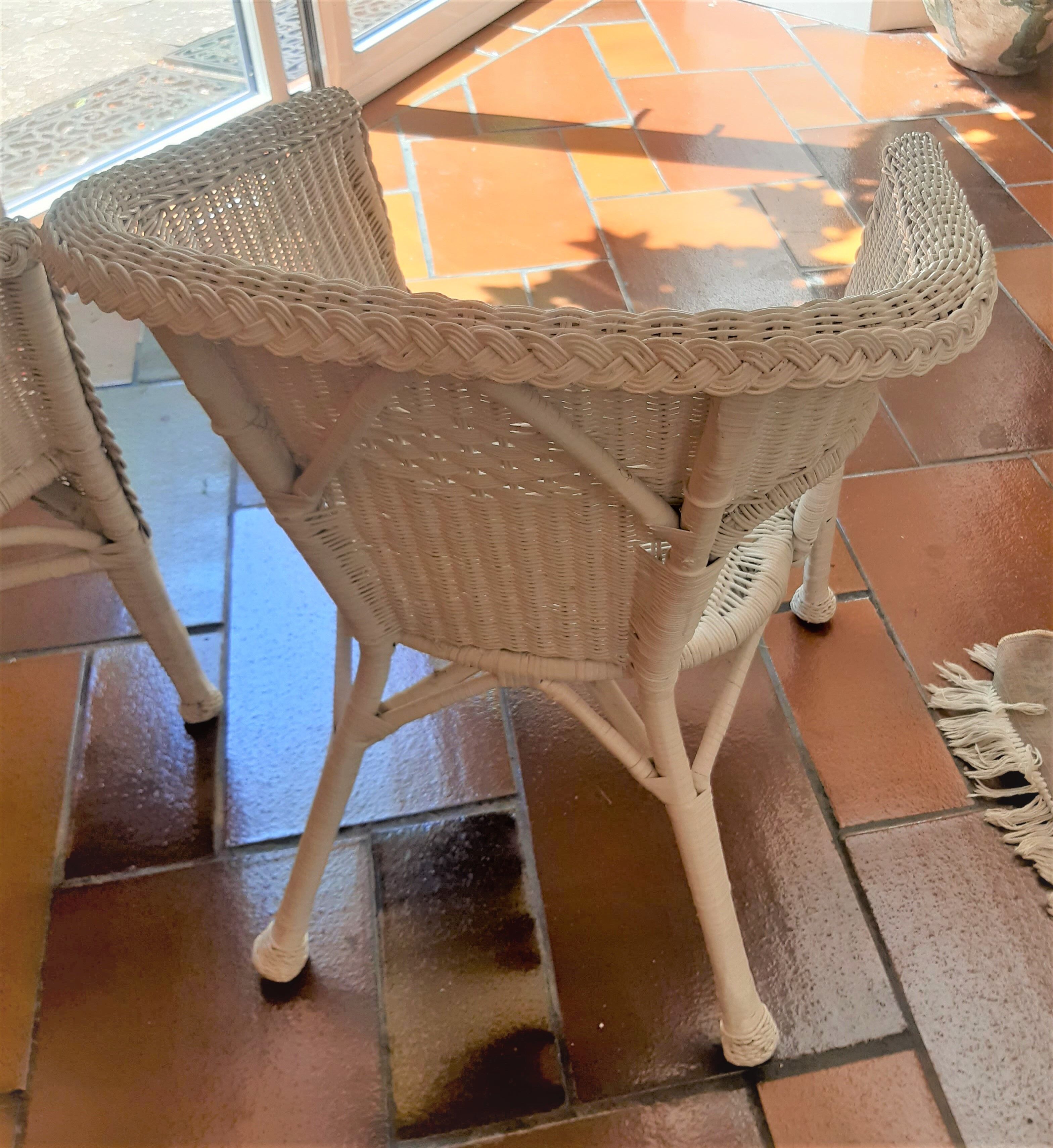 2 white wicker armchairs