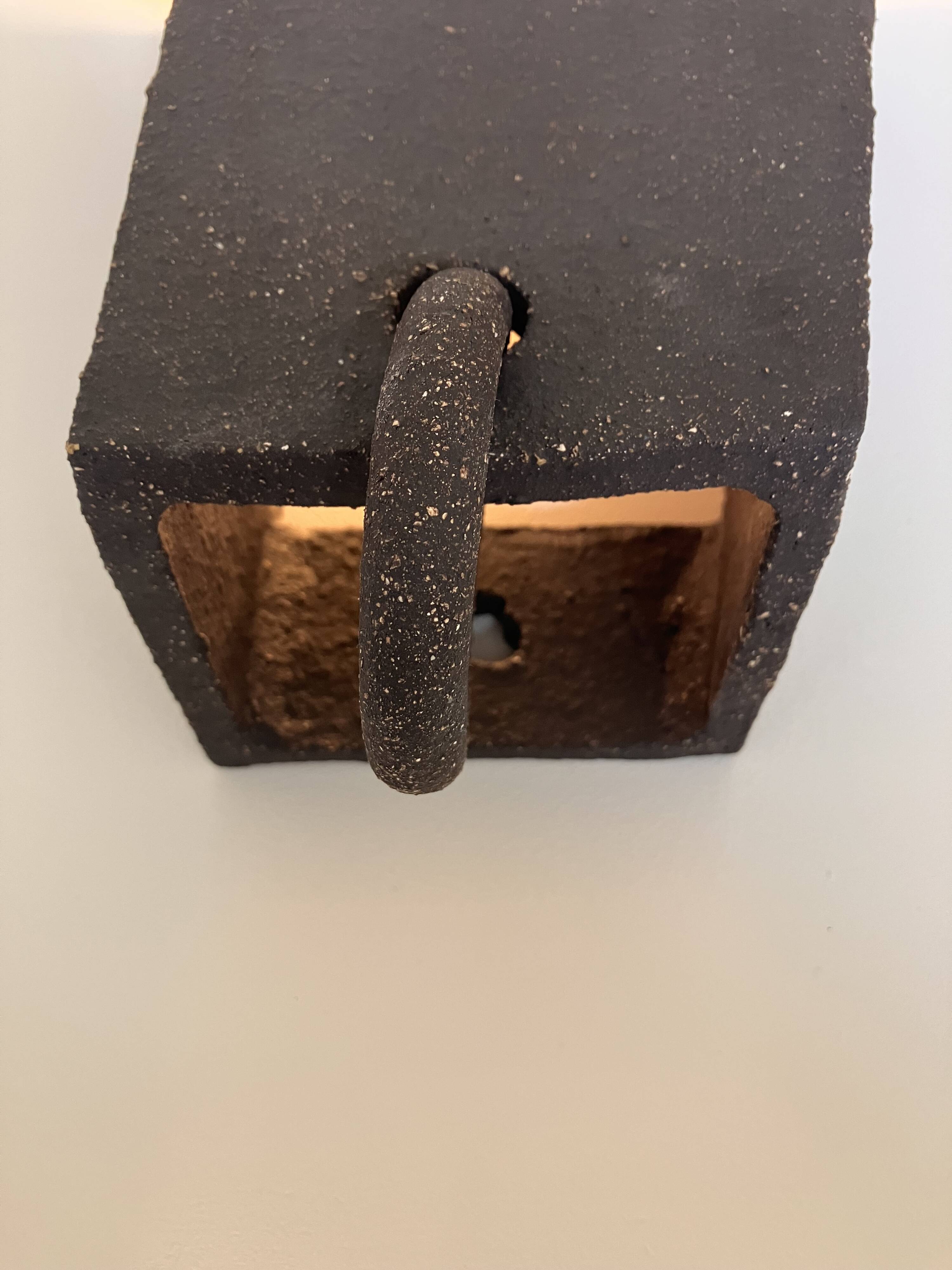 Graphical black stoneware ceramic wall light with handmade ring.