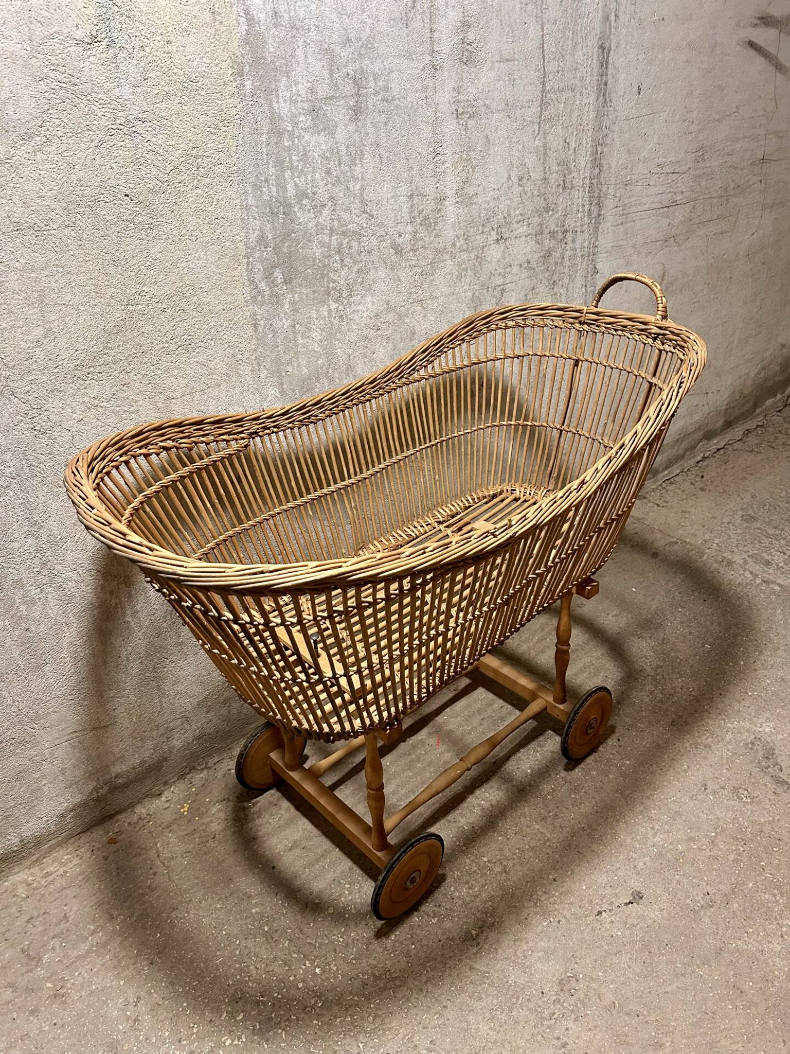 Vintage wicker cradle on wheels