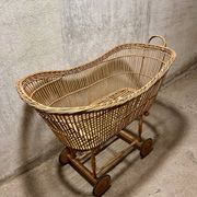 Vintage wicker cradle on wheels