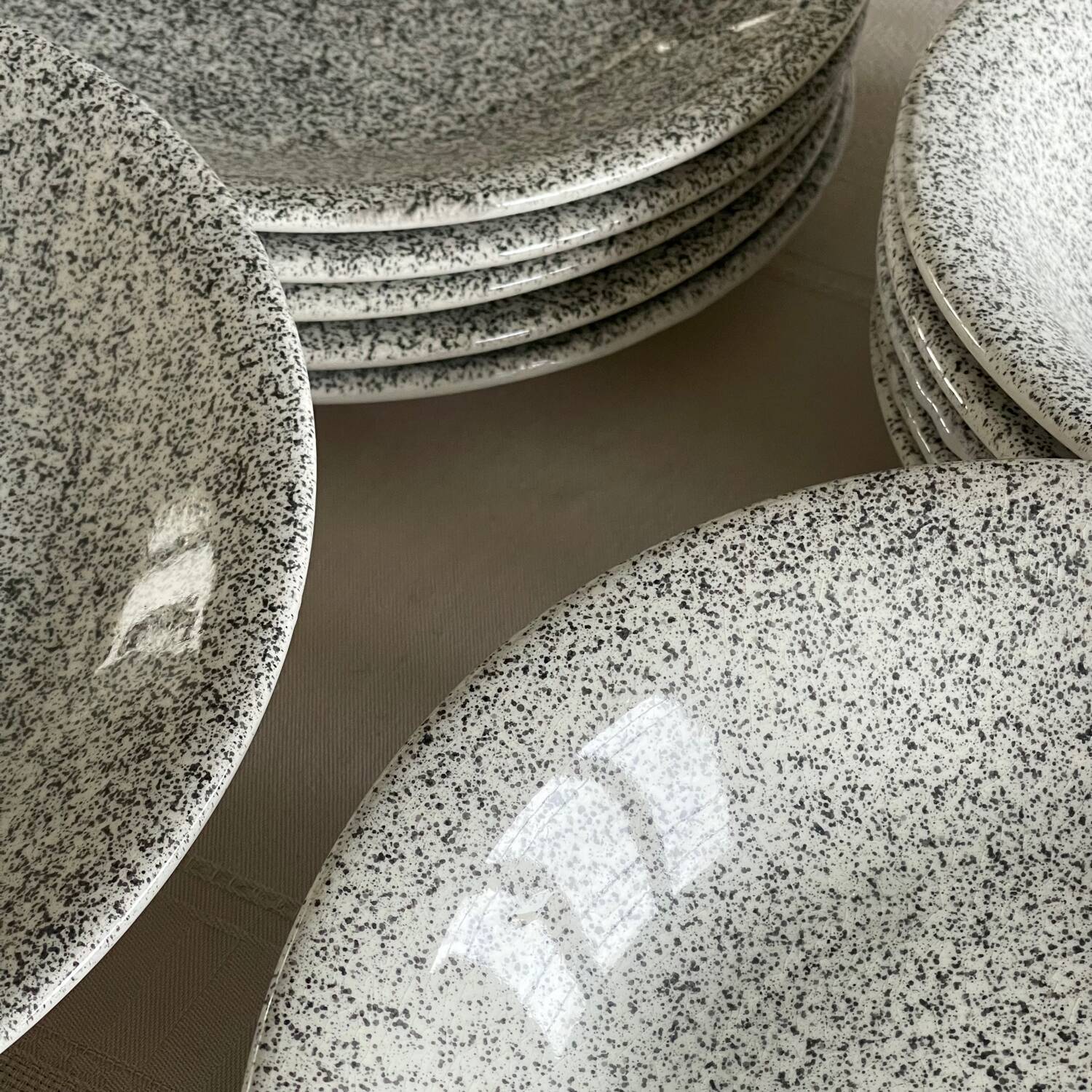 12 speckled ceramic plates.