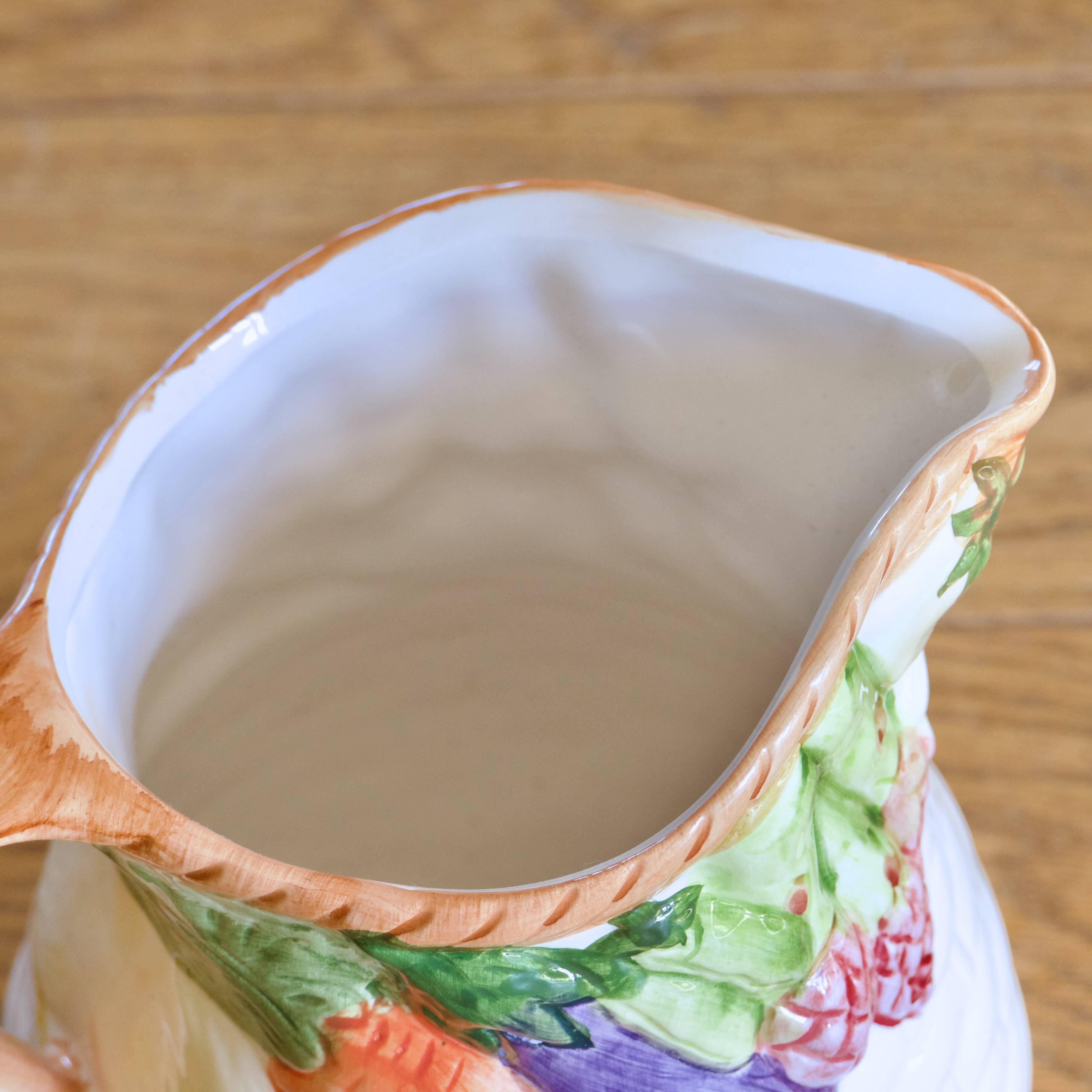 Hand-painted earthenware carafe with a raised vegetable basket design