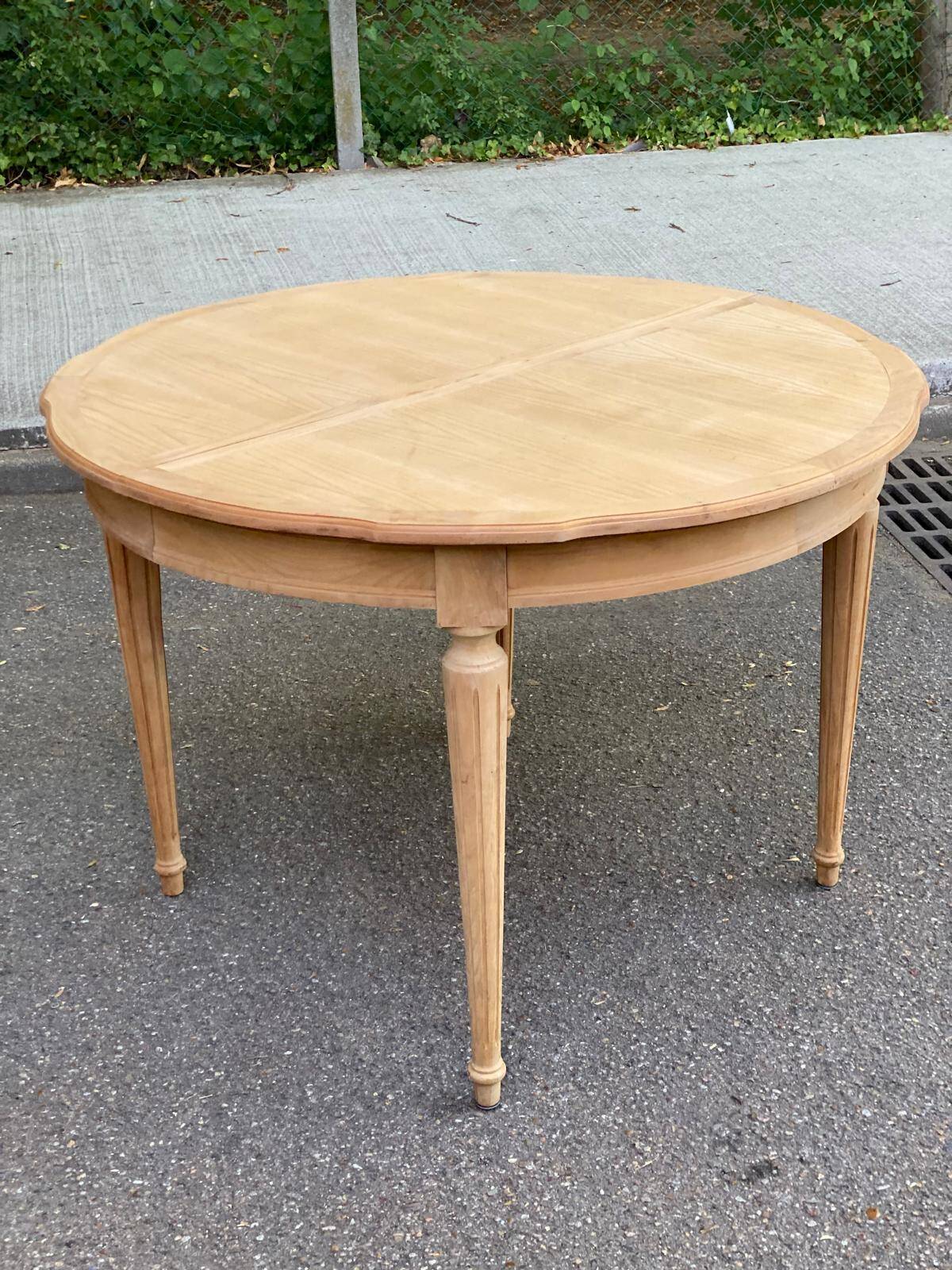 Extendable round table in renovated Louis XVI style, made of light wood, with 2 extensions.