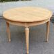 Extendable round table in renovated Louis XVI style, made of light wood, with 2 extensions.