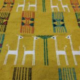Mustard colored carpet with gazelle patterns berber style