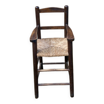 Vintage wooden children's high chair with straw.