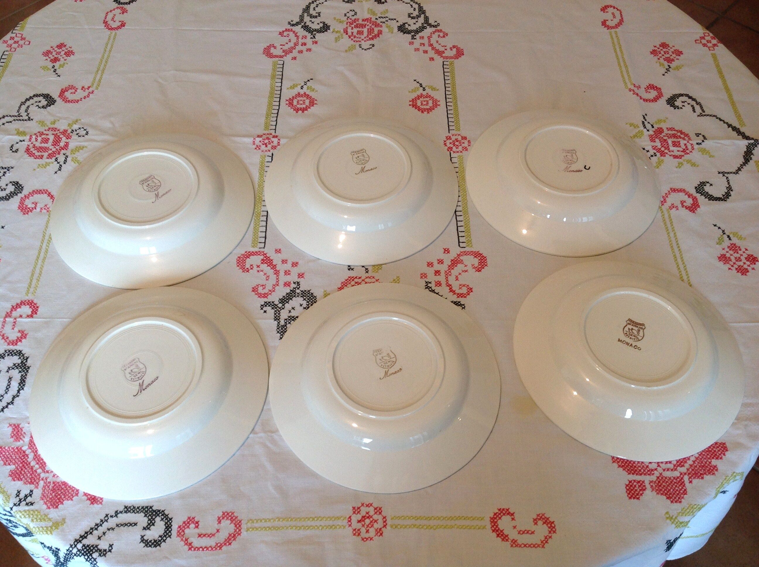 Six white hollow plates on board yellow Monaco 60