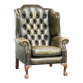 Fauteuil à oreilles Chesterfield en cuir de vachette vintage de couleur verte.