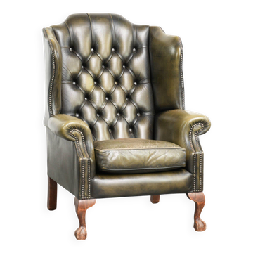 Fauteuil à oreilles Chesterfield en cuir de vachette vintage de couleur verte.