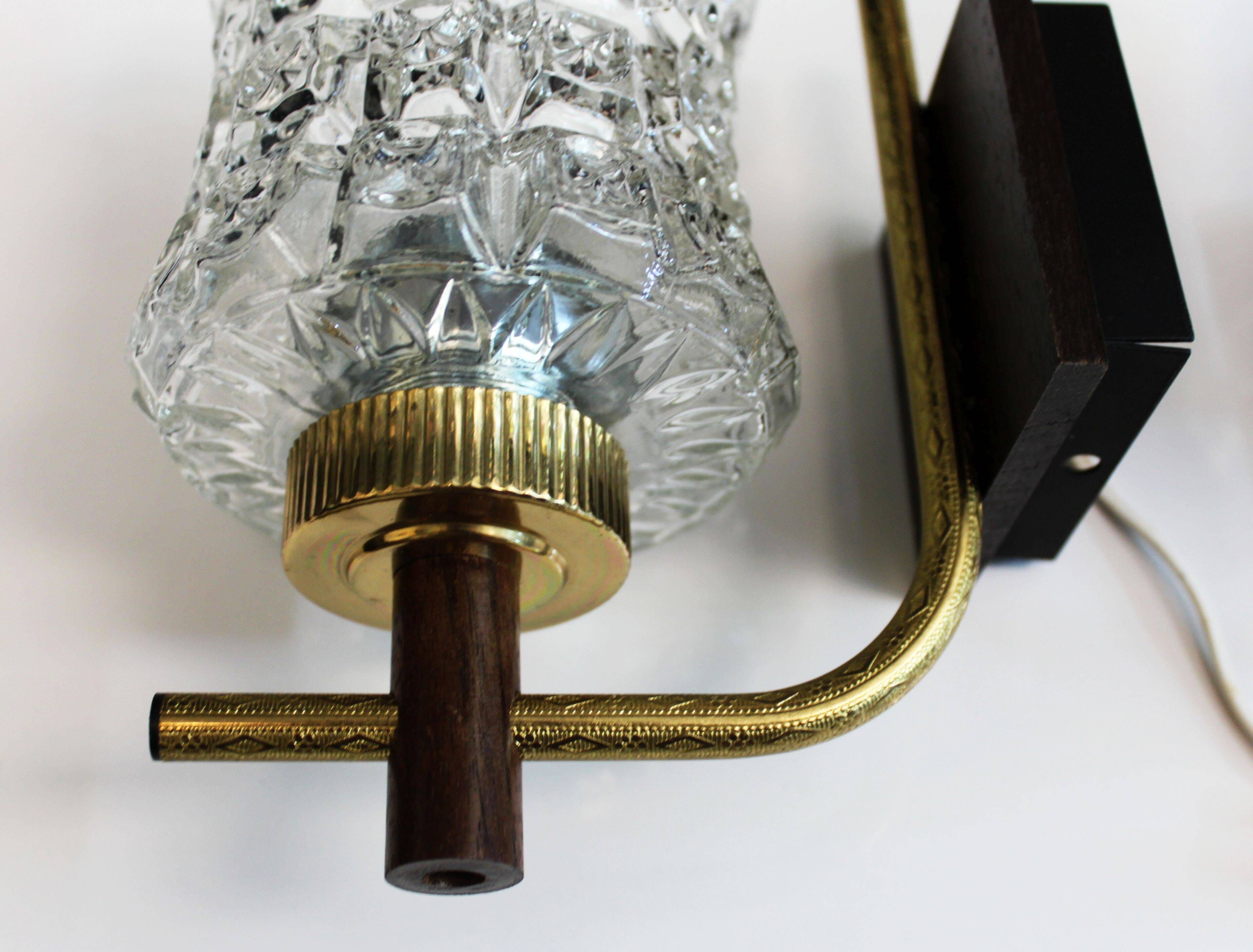 Pair of wall sconces in textured glass, wood, and gold metal, 1970.