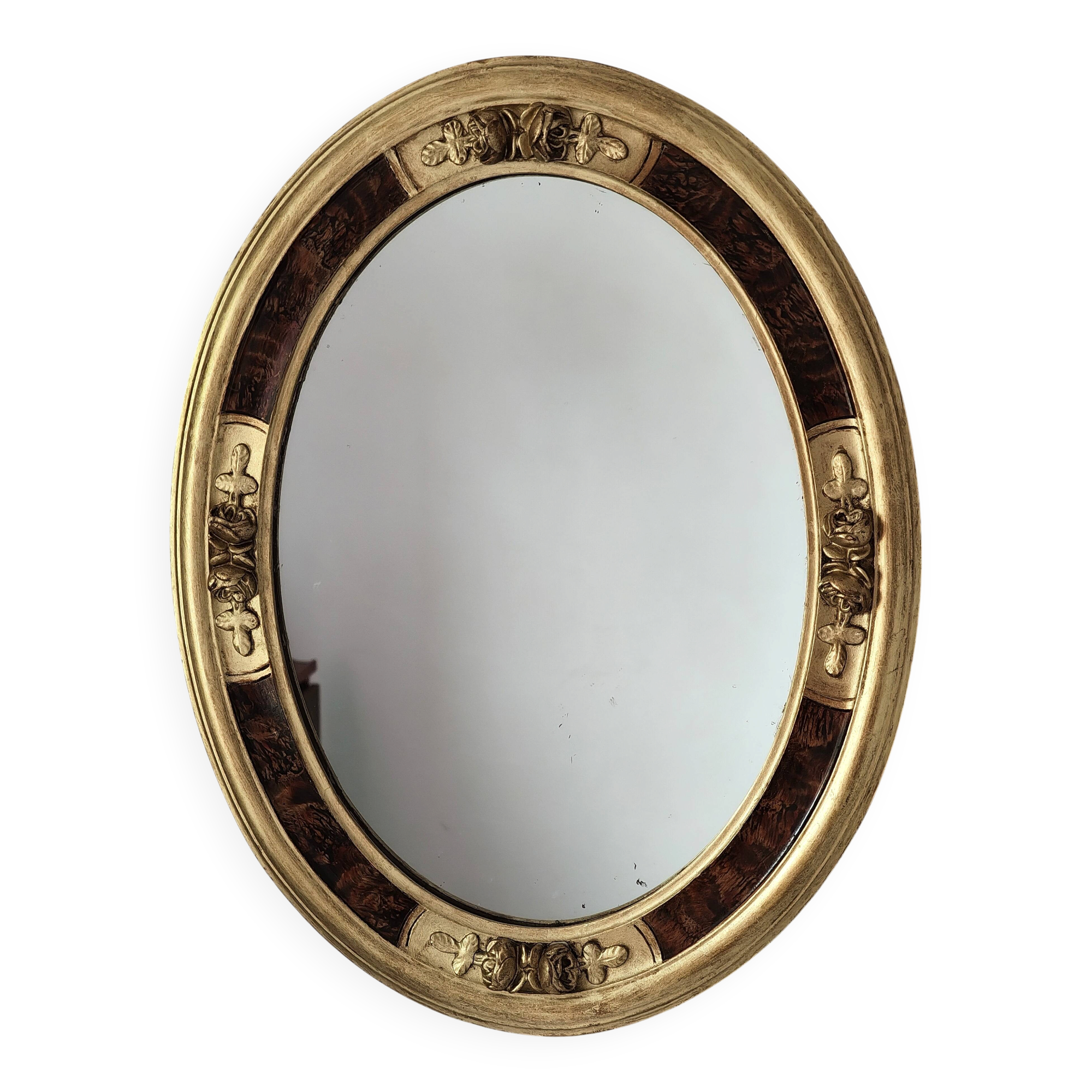 Antique medallion mirror with a gilded and relief-carved frame.