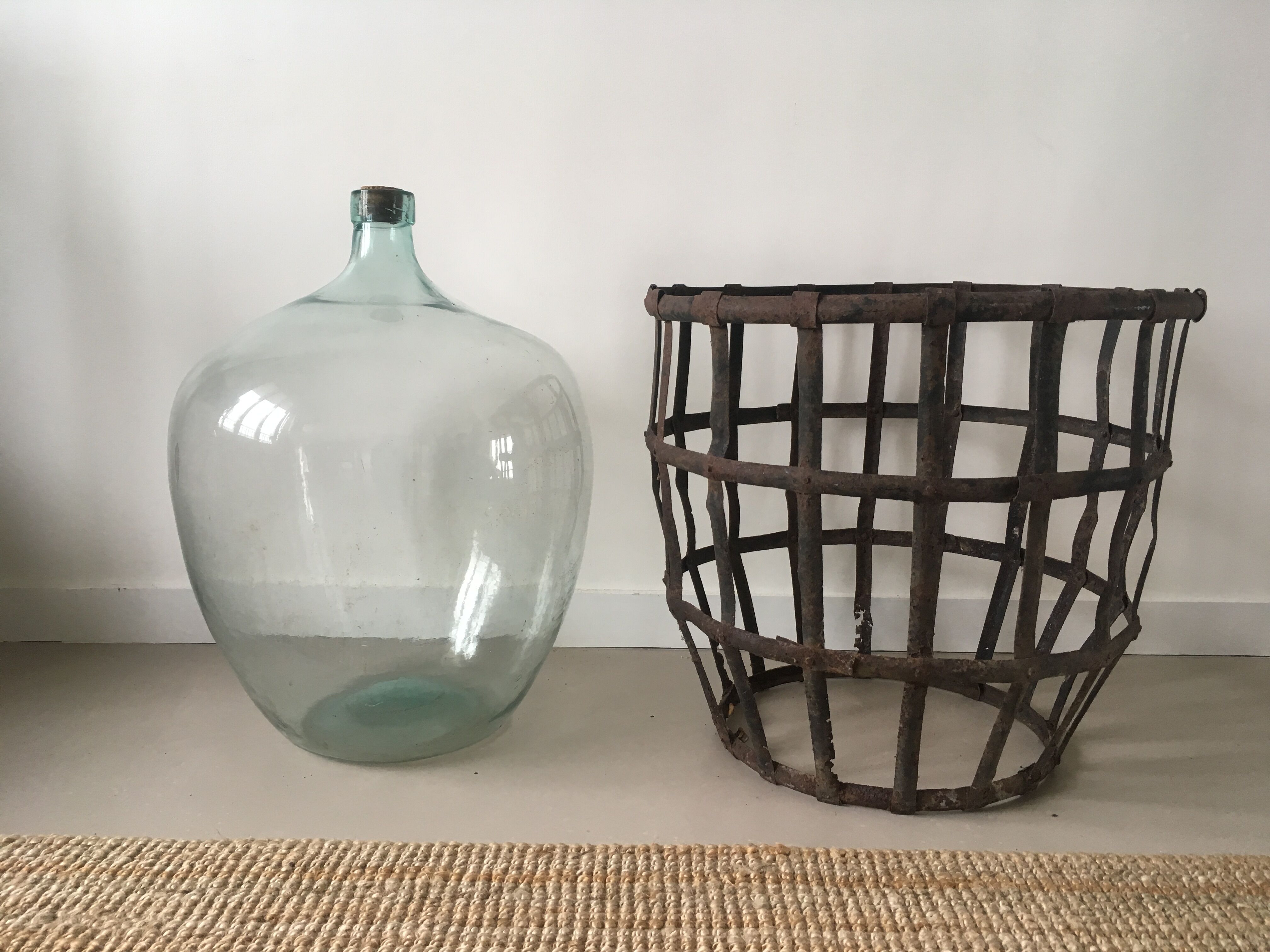 Old demijohn and her metal basket