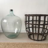 Old demijohn and her metal basket