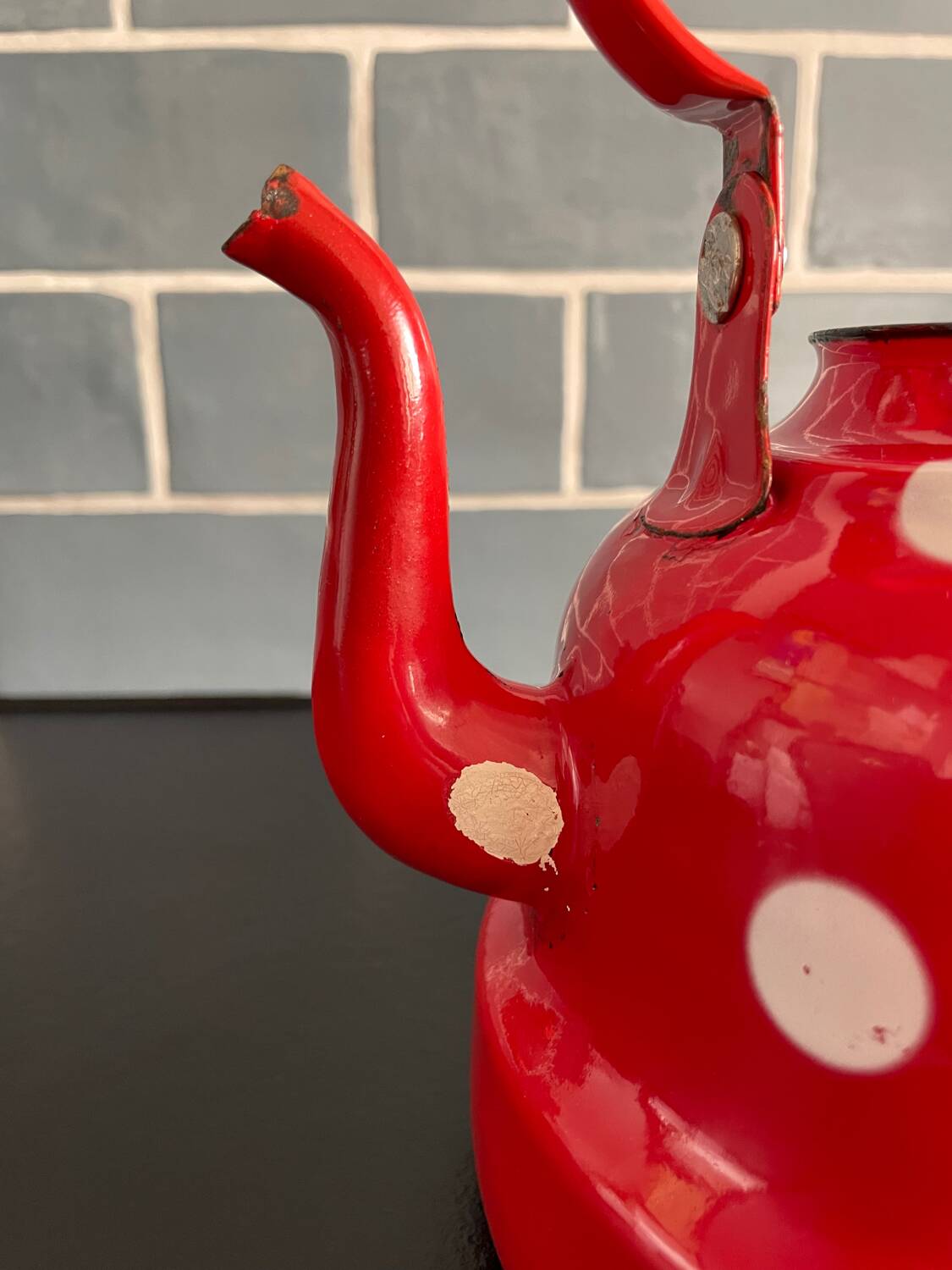 Red enameled sheet metal kettle with white polka dots