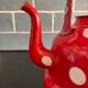 Red enameled sheet metal kettle with white polka dots