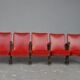 Series of 5 red skai and patinated cast Theater chairs
