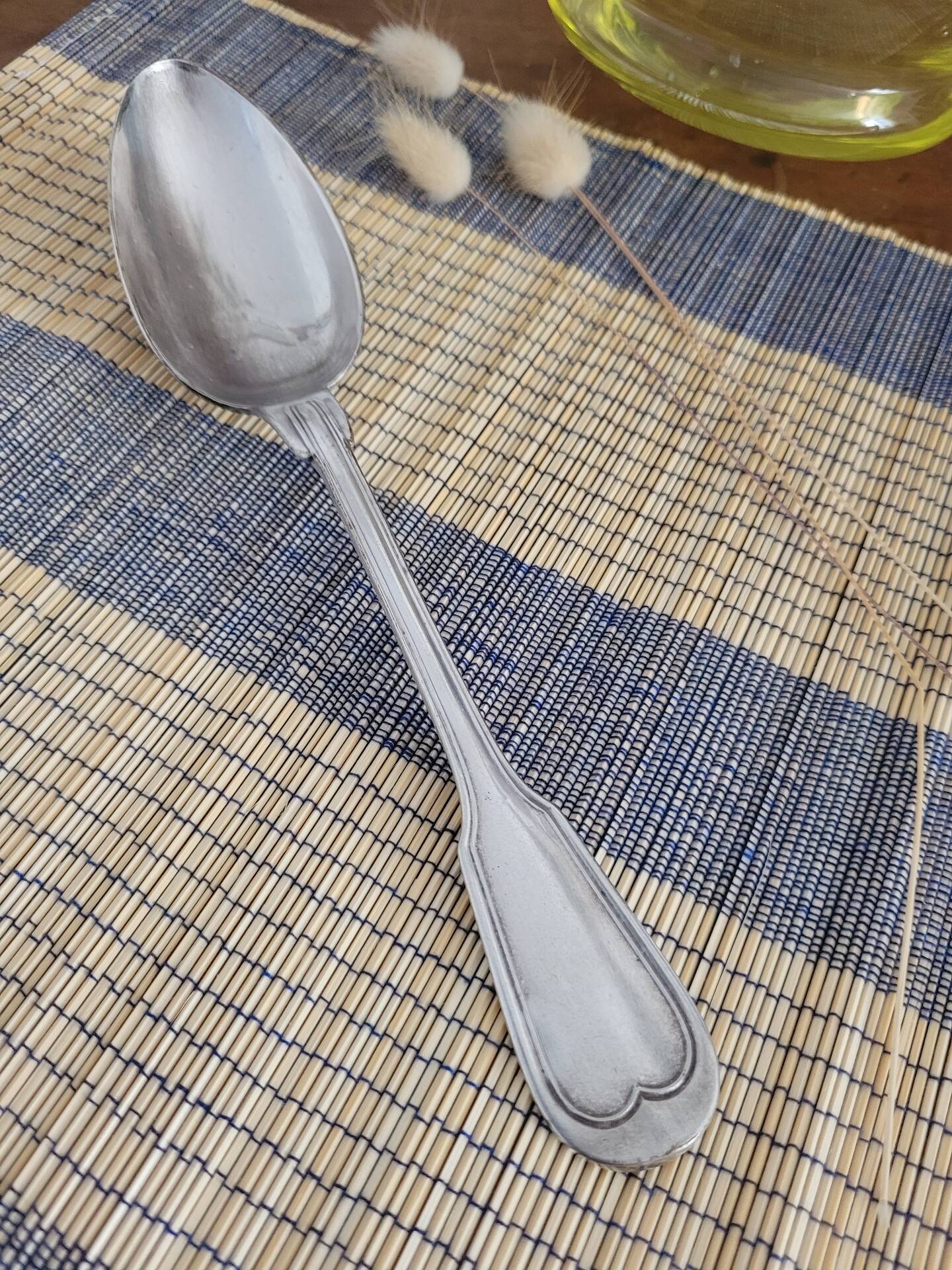 Large silver spoon with net decoration.