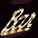 Enseigne lumineuse en lettrage aluminium formant le mot "bar"