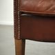 Characterful sheepskin club armchair in a dark cognac colour in English style