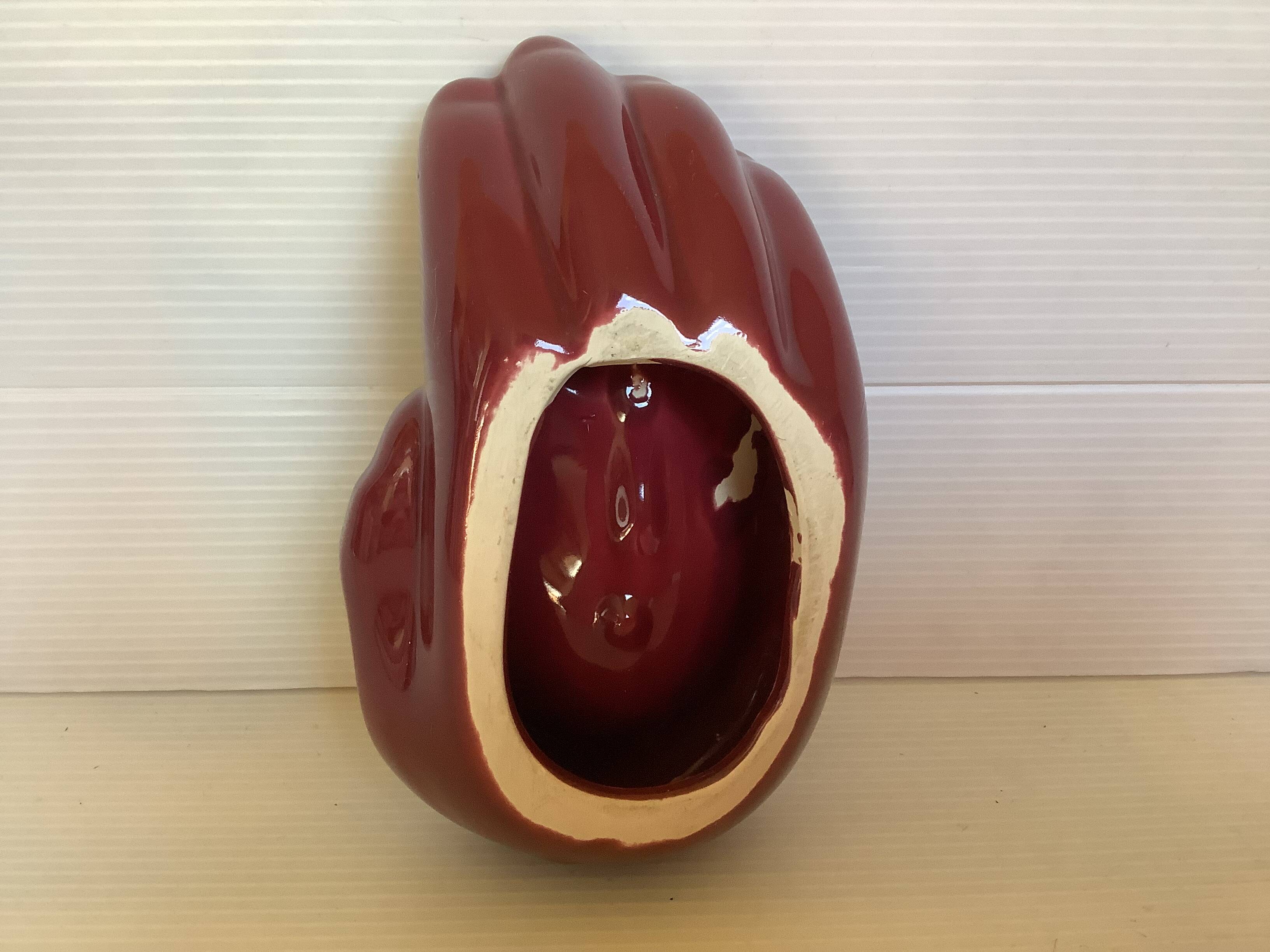 Empty pocket in the shape of a burgundy hand