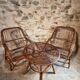 Vintage rattan lounge set, French wicker armchairs and round table, circa 1930–1950.