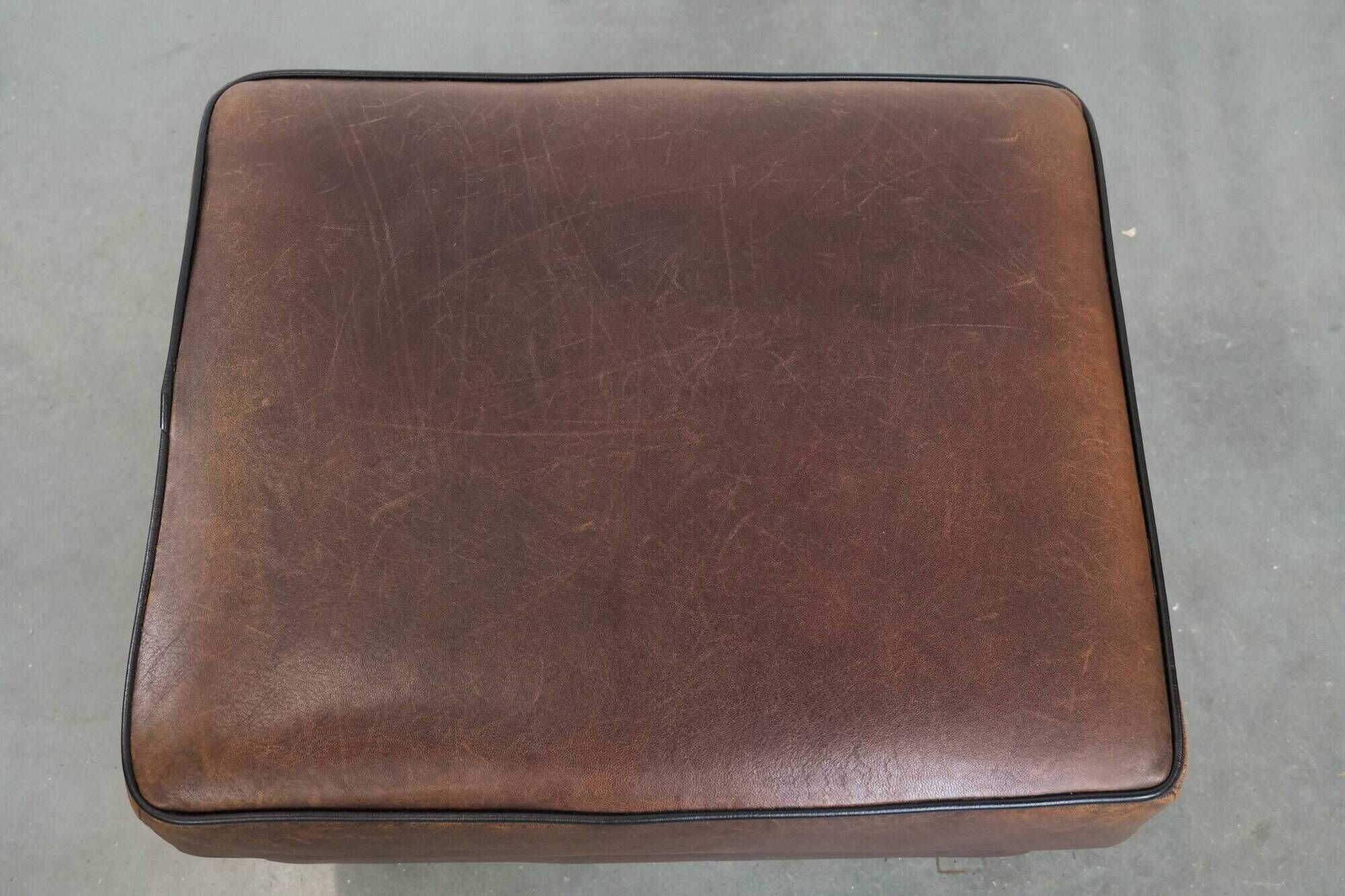 Sturdy vintage sheepskin ottoman in a beautiful large size with black piping