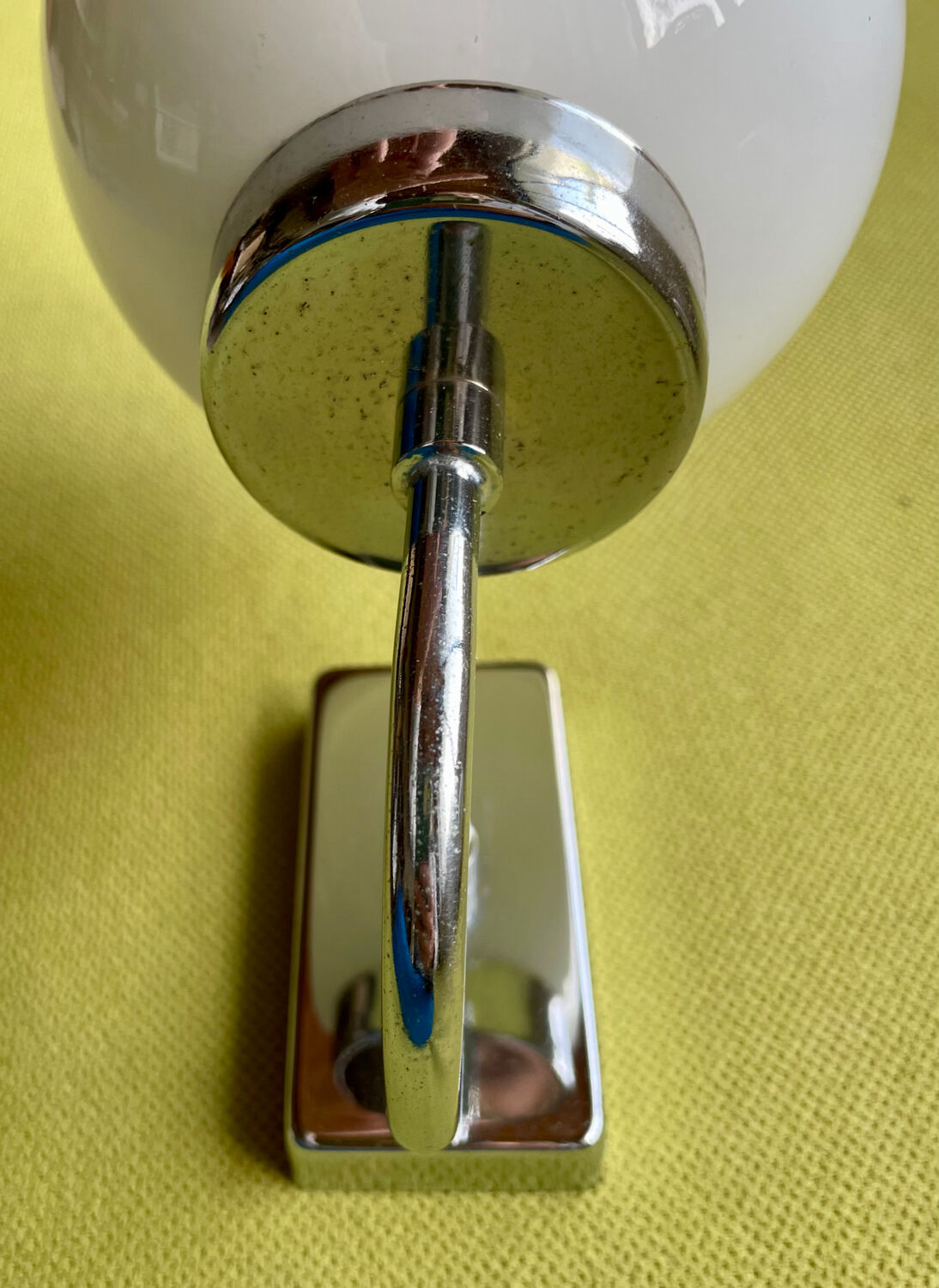 Pair of chrome metal wall lights with white glass globe.
