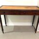 Antique English writing desk in mahogany and gilded leather.