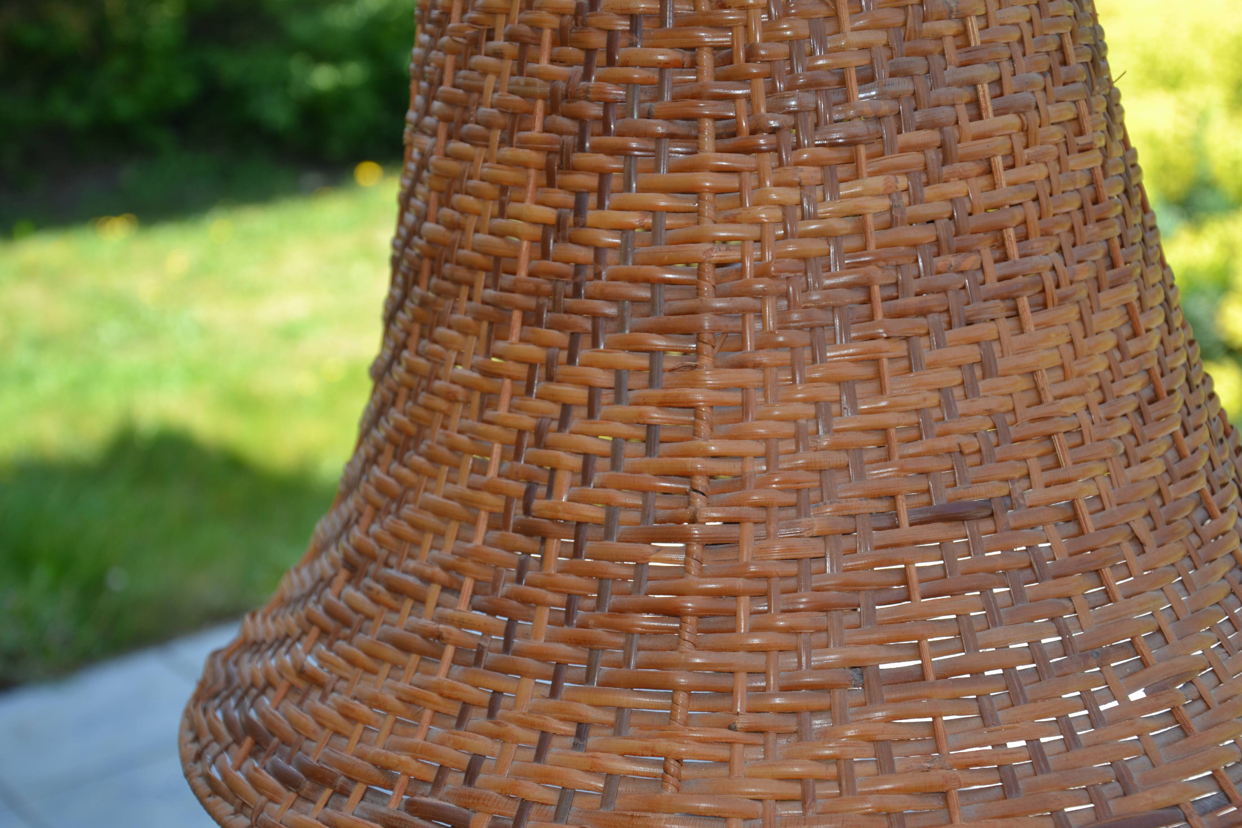Large wooden lamp with a woven rattan shade.